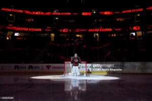 2 2026 436 | Photography and video news, reviews and tips | Henry's Camera Goaltender in front of the crease on a dark arena, spotlight on the ice and red LED boards reading 'James Reimer' and number 47 in the background.