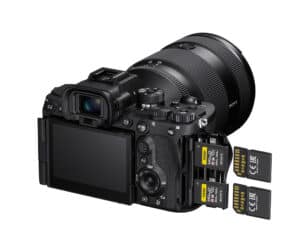 Digital SLR camera with a large zoom lens and three SD memory cards extending from the side.