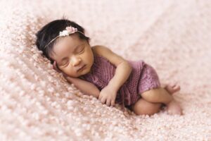 baby lying on pink fleece pad blanket