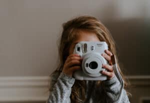 Little girl holding a Fujifilm Instax instant camera