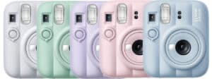Row of pastel Instax Mini 7S instant cameras in white, mint, lilac, pink, and blue.