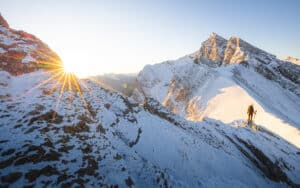 Hiker viewing a mountain sunrise on ridge