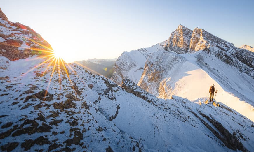 Hiker viewing a mountain sunrise on ridge