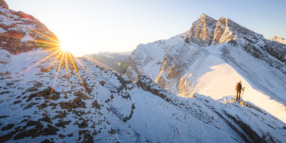 Hiker viewing a mountain sunrise on ridge