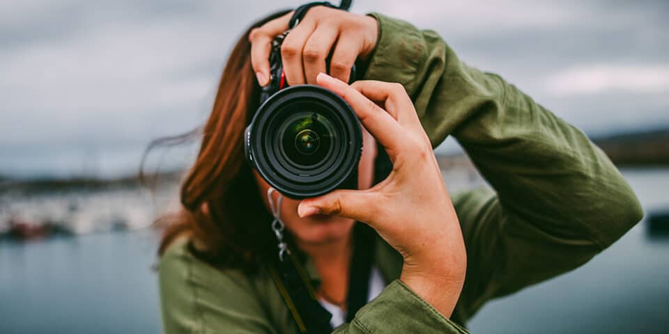 Female holding camera taking a photograph