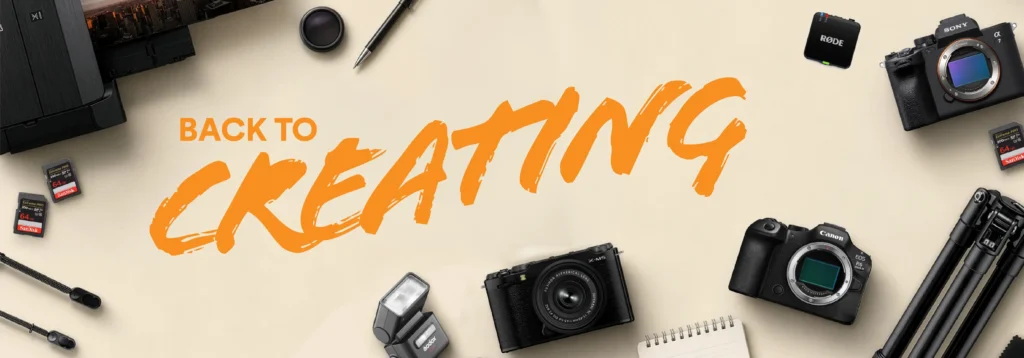 MACTAX | Photography and video news, reviews and tips | Henry's Camera Promotional banner with orange 'BACK TO CREATING' text surrounded by cameras, memory cards, lenses and tripods on a beige background.
