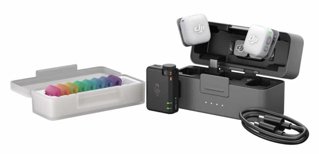 DJI wireless microphone kit with open charging case, two white earbuds, and a rainbow set of color-coded ear tips .