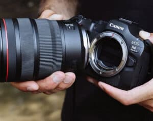 Close-up of a Canon EOS R6 Mark II camera body being held with a large zoom lens near the mount.