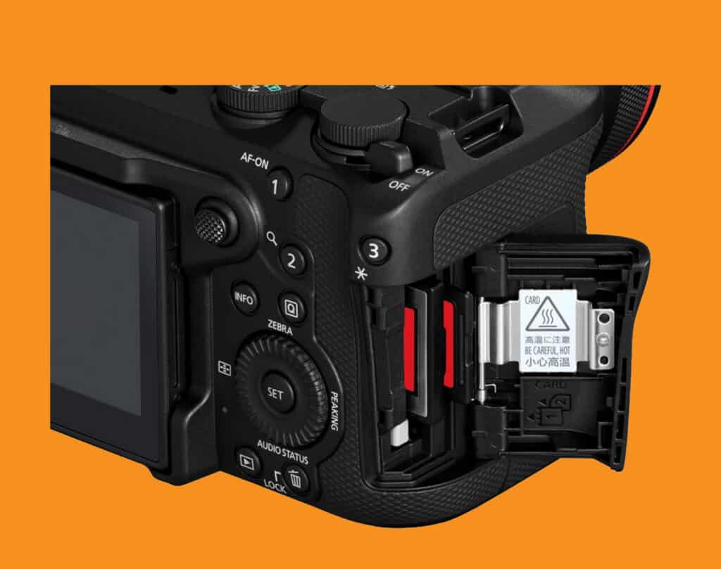 Close-up of a black DSLR camera with the memory card slot open on the side against an orange background.