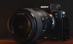 Close-up of a Sony mirrorless camera with a large GM lens mounted, front element visible in focus.